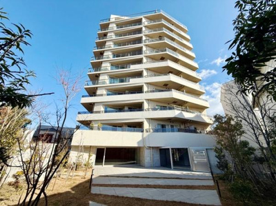 青空に映える明るい色調の外観が印象的です。バルコニーが各住戸に備わっており開放感のあるデザインです。駐車スペースも複数台分しっかり確保されています。周囲との調和がとれた現代的なマンションです。