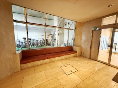 開放感のある広々としたロビーに設けられたベンチスペースが特徴的です。明るい採光とガラス張りのデザインが印象的でシンプルな床材が落ち着いた印象を与えます。