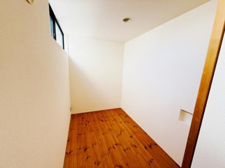 シンプルなデザインの室内で温かみのある木目調の床材が魅力です。壁面には小さな開口部があり空間にアクセントを加えています。天井部分にはダウンライトが設置されています。