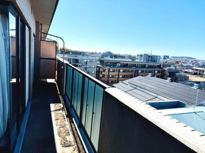 バルコニーからの見晴らしが広がり開放感のある空間が広がっています。ガラスパネルの手すりがすっきりとした印象を与えています。長さのあるバルコニーは活用の幅が広がります。採光も十分に確保されています。