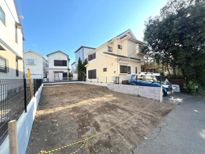 現地写真から広々とした土地の様子が伝わります。前面道路も整備されており周囲には住宅が立ち並んでいます。陽当たりが良く開放感のある雰囲気です。敷地の区画もわかりやすく現地の状況が把握しやすい写真です。