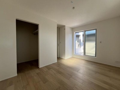 洋室は二面採光で明るく床や壁の色合いが落ち着いた雰囲気を感じさせます。収納スペースがしっかりと確保されています。窓から外の景色を楽しめる設計です。室内はすっきりとした印象です。