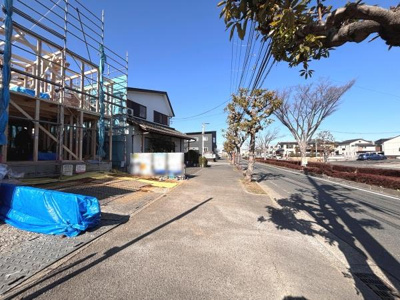 前面道路が広く開放感のある現地写真です。周囲には整然とした街路樹が続き明るい雰囲気が感じられます。道路沿いは見通しが良く周辺環境も分かりやすい写真です。