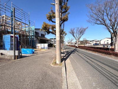 敷地前には広々とした歩道があり安心して移動できます。道路は見通しが良く車の出入りがしやすい環境です。周囲には建設中の建物も見られ街並みに新しい印象が感じられます。並木道が続き季節の変化も楽しめます。