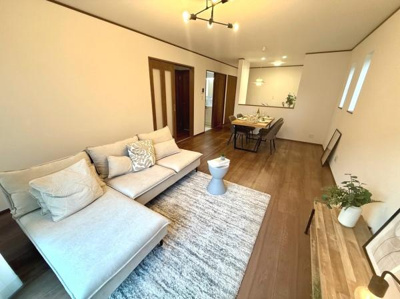 リビングは明るい色合いの家具とシンプルな内装が調和した空間です。広々としたレイアウトで家具の配置もゆとりがあります。窓からの採光により室内が明るく保たれています。