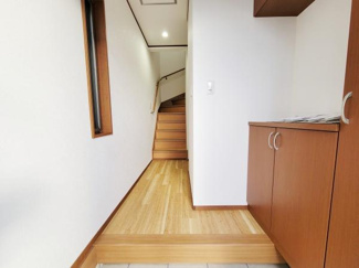 玄関は収納スペースが充実し靴や小物の整理に便利です。自然光が差し込む窓があり明るい印象を受けます。木目調の床が温かみを感じられる空間です。階段へと続く動線がスムーズです。