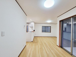 開放感のあるリビングが広がっております。ナチュラルな木目のフローリングが印象的です。天井の照明が空間を明るく照らします。窓やスライドドアからの採光も良好です。壁の色合いも落ち着いています。