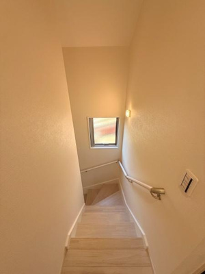 明るい色合いの階段が空間全体をすっきりとした印象にしています。手すりが設置されており移動の際も安心感があります。窓からの自然光が階段をやさしく照らしてくれます。清潔感のある仕上がりが魅力的です。