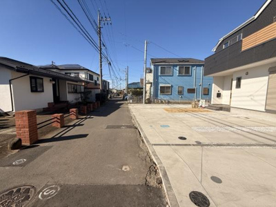 前面道路は広々としており車の出入りもスムーズに行えます。敷地と道路の段差が少ないため移動も便利です。日中は陽当たりもしっかりと確保されています。周囲の住宅も整然と並んでおり開放感があります。