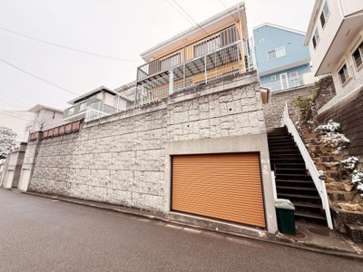 オレンジ色の外観が特徴的な建物です。高台に位置し周囲の建物と比べて見晴らしが良い印象です。広めの階段アプローチがあり重厚感ある石垣も魅力の一つです。道路からのアクセスも便利です。