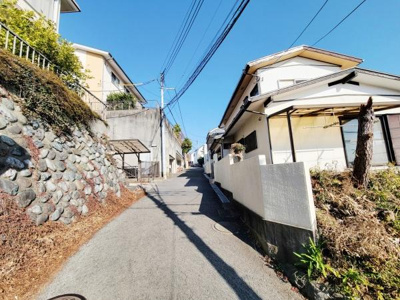 前面道路はゆるやかな傾斜があり周囲には住宅が整然と立ち並んでいます。道幅はしっかり確保されており車の通行も安心です。青空の下落ち着いた雰囲気のエリアとなっております。周辺環境もすっきりしています。