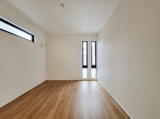 ナチュラルな木目調フローリングが特徴の洋室です。縦長の窓から程よく光が差し込みます。シンプルな内装で家具のレイアウトもしやすい空間です。壁面にアクセントとなるスリット窓も設けられています。