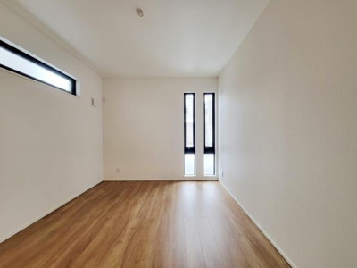 ナチュラルな木目調フローリングが特徴の洋室です。縦長の窓から程よく光が差し込みます。シンプルな内装で家具のレイアウトもしやすい空間です。壁面にアクセントとなるスリット窓も設けられています。