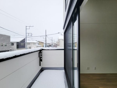 幅のあるバルコニーが広がり開放感を感じられます。ガラス扉で室内との繋がりも良好です。ゆとりあるスペースが印象的です。近隣の住宅との距離感も確保されています。