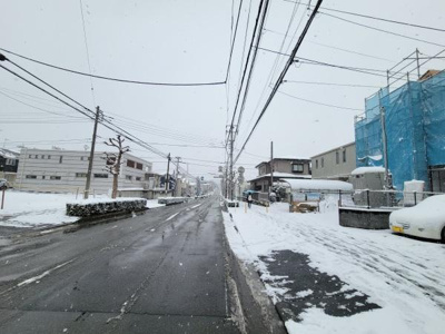 前面道路がしっかりと整備されており車の出入りもしやすい環境です。周辺には住宅が建ち並び落ち着いた雰囲気が感じられます。雪の日でも道路幅にゆとりがあり通行に配慮されています。