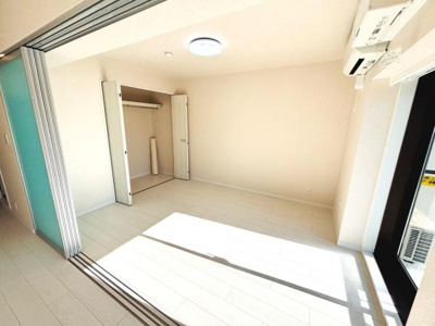 明るい光が差し込む洋室です。シンプルな内装で様々なインテリアに合わせやすい空間となっています。クローゼット付きで収納も確保されています。広さを感じられる間取りが特徴です。