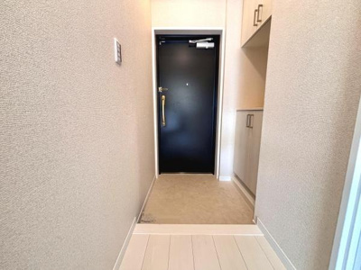 明るい玄関は清潔感のある印象を与えます。収納スペースも完備されておりすっきりとした空間です。シンプルな内装で使い勝手の良さが感じられます。広さも十分に確保されています。手すり付きの扉で安心です。