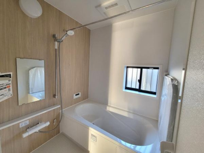浴室には大きめの窓が設置されており明るい自然光が差し込みます。壁面はウッド調で落ち着いた雰囲気です。手元のシャワーやミラーなど使いやすさに配慮された設備が揃っています。