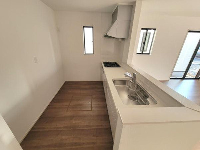 窓が設けられておりキッチンに自然光が差し込みます。シンクとコンロが一直線に配置されていて動線がすっきりとしています。カウンターがキッチンとリビングを緩やかにつなぎます。