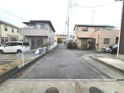 前面道路は幅がしっかりと確保されており車の出し入れもスムーズに行えます。周囲は住宅が建ち並び静かな雰囲気が感じられます。道路沿いにはフェンスもあり整然とした街並みが広がっています。