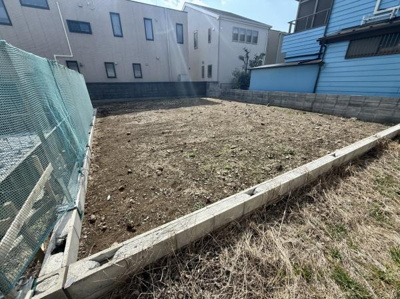 現地土地写真にて更地の様子が分かりやすく撮影されています。周囲はフェンスやブロック塀で囲われており区画も明確です。整備された状態が確認でき陽当たりも良好です。周囲の住宅も見え落ち着いた印象です。