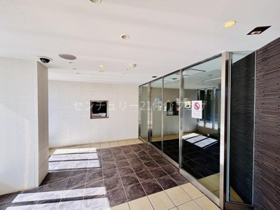 陽当たりの良い道路沿いに位置し建物の外観が印象的です。周囲には緑や花壇が整備されており開放感のある環境です。広々とした歩道が設けられており快適な生活を想像できます。