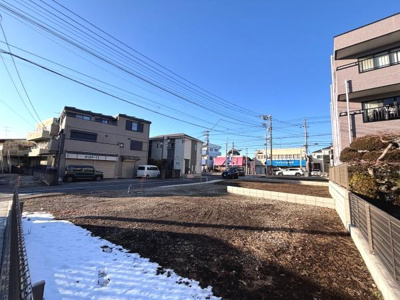 晴れた青空と広々とした敷地が魅力を引き立てます。落ち着いた住宅街の雰囲気も感じられます。前面道路が広く車の出入りも便利そうです。