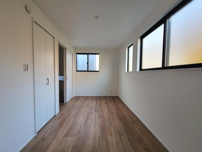 洋室はシンプルな内装でさまざまなスタイルに合わせやすい空間です。複数の窓からは自然光がしっかりと入ります。収納スペースも備わっていて便利です。フローリングの色合いが落ち着いた印象を与えます。