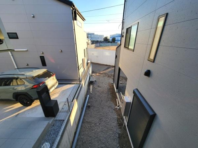 日当たりの良い空間が広がる明るい雰囲気の住宅です。建物同士の距離も確保されています。車の出し入れがしやすそうな駐車スペースが配置されています。建物の外観もシンプルでモダンなデザインです。