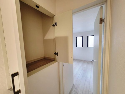 収納スペースが廊下の一角に設けられており使いやすい高さに配置されています。扉付きで中身をすっきり隠せる仕様です。お部屋の一体感を損なわないデザインです。収納の使い勝手にも配慮されています。