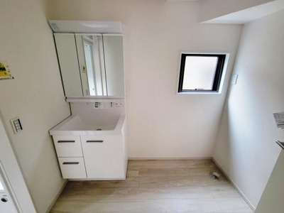 洗面台はミラー収納付きですっきりとしたデザインが特徴です。明るい空間でお手入れもしやすい床材となっています。換気を考慮した窓も備え付けられており使い勝手の良さが感じられます。