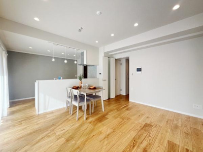 リビングはナチュラルな木目フローリングが広がり開放感のある空間です。ダウンライトが明るさを確保しシンプルな白い壁が室内をすっきりとした印象に保っています。