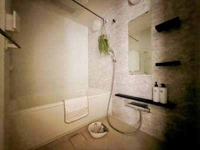 浴槽と洗い場がゆったりと確保されたバスルームです。壁面のシンプルなデザインが落ち着いた雰囲気を演出しています。棚が複数設置されており小物の収納にも便利です。ミラーも大きく使いやすさが感じられます。