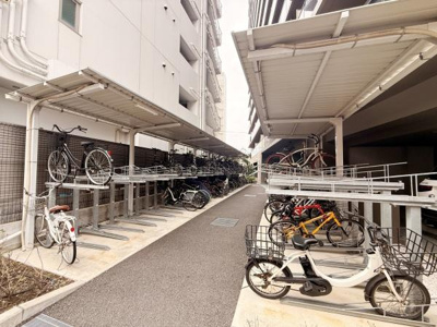 屋根付きの駐輪場がしっかりと設置されており雨の日でも自転車を守ることができます。上下2段タイプのため多くの自転車が収納可能です。全体的に整然とした印象でゆとりあるスペースが確保されています。