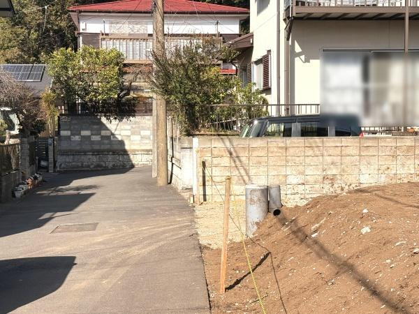 前面道路を含む現地写真です。道路幅がしっかり確保されており車の出入りもスムーズに行えます。周辺は落ち着いた住宅街で建物との距離感も明確です。陽当たりの良さも感じられる立地です。
