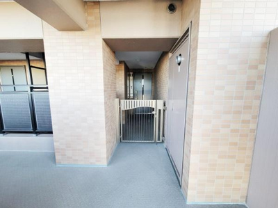 落ち着いた色合いのタイル壁が印象的な玄関スペースです。プライバシーに配慮された造りで安心感があります。