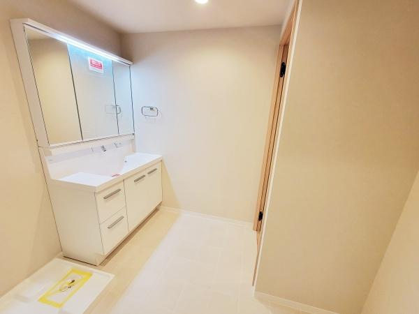 収納力がある洗面台は毎日の使い勝手を考慮した設計です。大きな鏡は身だしなみのチェックに便利です。全体的に清潔感のある空間に仕上がっています。照明も明るく日々の準備が快適に行えます。