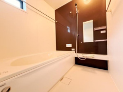 シンプルで使いやすいバスルームです。大きめの鏡と収納棚が配置されていて便利です。明るい窓から自然光が入ります。浴槽はゆったりとしたサイズ感です。