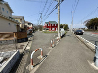 広々とした歩道と整備された道路が続き開放感のある街並みが特徴です。周囲には落ち着いた住宅が並び電柱やガードレールなどインフラ面も充実しています。遠くには緑も見え街全体が整った雰囲気です。