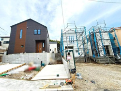 外観の異なる2つの建物が並び片方は完成済みもう片方は建築中です。敷地は広く開放感があり駐車スペースも確保されています。周囲の住宅とも調和した印象を受けます。シンプルかつ現代的な雰囲気が伝わってきます。