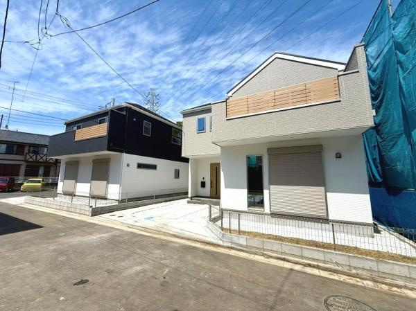 現地写真からは建物外観が明るく清潔感のある印象を受けます。前面道路も広く車の出し入れがしやすい配置です。外構スペースもゆとりがあり駐車スペースが確保されています。現地の雰囲気がよく伝わる写真です。