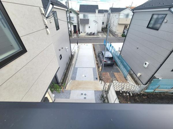 住宅街の落ち着いた雰囲気が感じられる現地からの眺望です。周辺が整理されていて道路や駐車スペースもしっかりと確保されています。建物の配置やスペース感も分かりやすい眺望写真です。