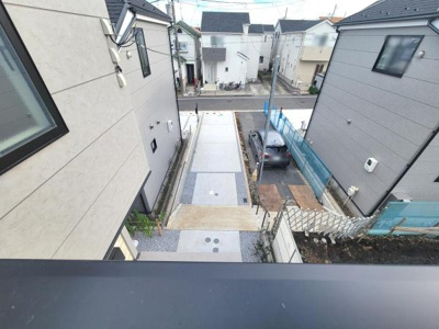 住宅街の落ち着いた雰囲気が感じられる現地からの眺望です。周辺が整理されていて道路や駐車スペースもしっかりと確保されています。建物の配置やスペース感も分かりやすい眺望写真です。