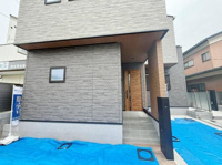 シックな外観デザインが目を引く住宅です。玄関までのアプローチが特徴的で建物全体に統一感があります。窓や扉もスタイリッシュな印象を与えます。外壁の質感が落ち着いた雰囲気を演出しています。