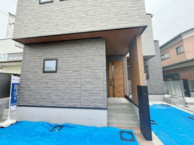 シックな外観デザインが目を引く住宅です。玄関までのアプローチが特徴的で建物全体に統一感があります。窓や扉もスタイリッシュな印象を与えます。外壁の質感が落ち着いた雰囲気を演出しています。