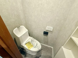 シンプルな内装で使いやすさを重視したトイレです。小窓が設けられており自然な明るさを取り入れられます。収納スペースもあり実用的なレイアウトです。壁紙と床材の組み合わせが落ち着いた雰囲気を演出しています。