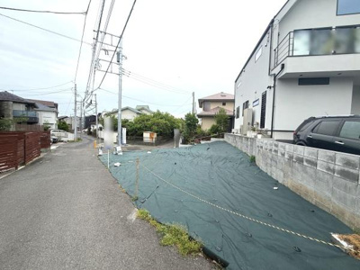 現地は幅のある前面道路に面しており車の出入りもしやすい環境です。近隣には住宅が整然と並び静かな印象を受けます。敷地前面はゆとりあるスペースが確保されています。電柱や配線も整備されたエリアです。