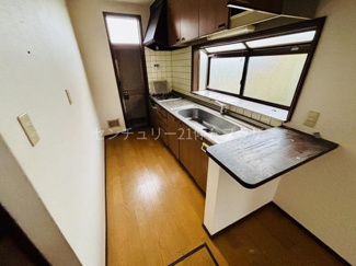 窓からの採光があり明るい印象のキッチンです。調理スペースが確保されており作業がしやすいレイアウトです。収納棚が上部に備わっているためキッチン用品の整理も便利です。