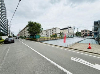 現地前面道路は幅員が広めで車の出入りもしやすそうです。周辺にはマンションや住宅が立ち並び落ち着いた雰囲気が感じられます。