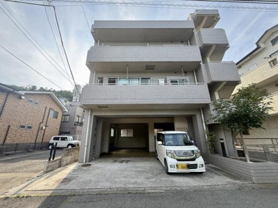 シンプルな外観が特徴のマンションです。広めの駐車スペースが設けられており車の出し入れがしやすい構造です。周囲には落ち着いた住宅が並び開放的な印象を与えています。